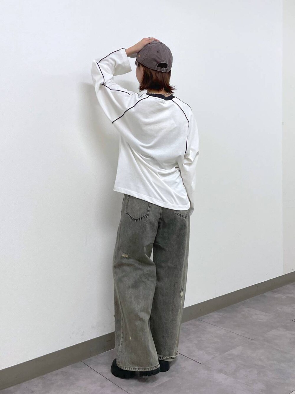 ブラック系のデニムパンツ、ブラック系のブーツ、ホワイト系のTシャツ/カットソーを着用したレディースの秋コーディネートの3枚目の写真