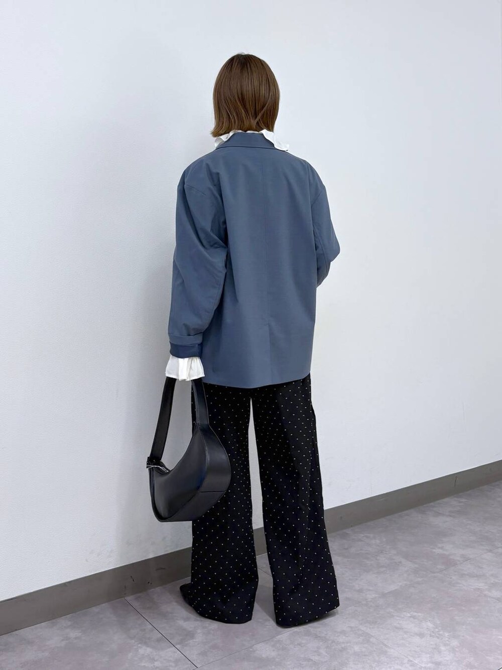 ブルー系のテーラードジャケット、ブラック系のスラックス、ホワイト系のシャツ/ブラウスを着用したレディースの冬コーディネートの4枚目の写真