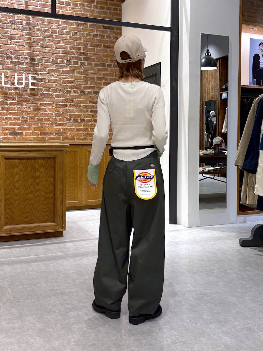 ブラック系のボディバッグ/ウエストポーチ、ホワイト系のニット/セーター、ベージュ系のキャップを着用したレディースの春コーディネートの4枚目の写真