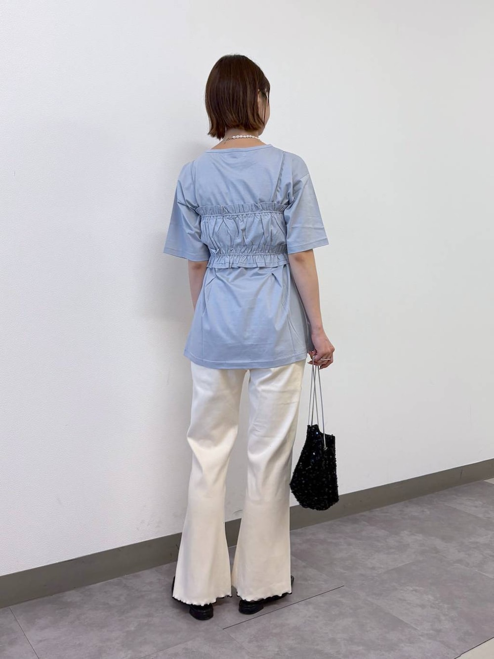 ブルー系のTシャツ/カットソー、ホワイト系のスウェットパンツ、ブラック系のハンドバッグを着用したレディースの夏コーディネートの3枚目の写真