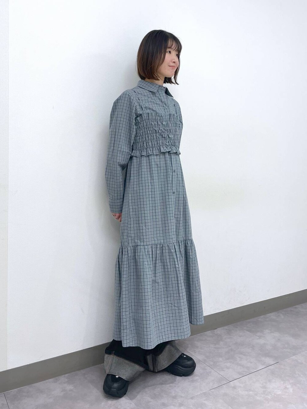 ブラック系のスニーカー、ブルー系のシャツワンピース、ブラック系のデニムパンツを着用したレディースの春コーディネートの3枚目の写真