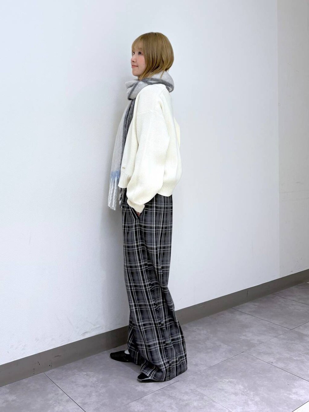 ホワイト系のニット/セーター、ブラック系のスラックス、ホワイト系のマフラーを着用したレディースの冬コーディネートの3枚目の写真