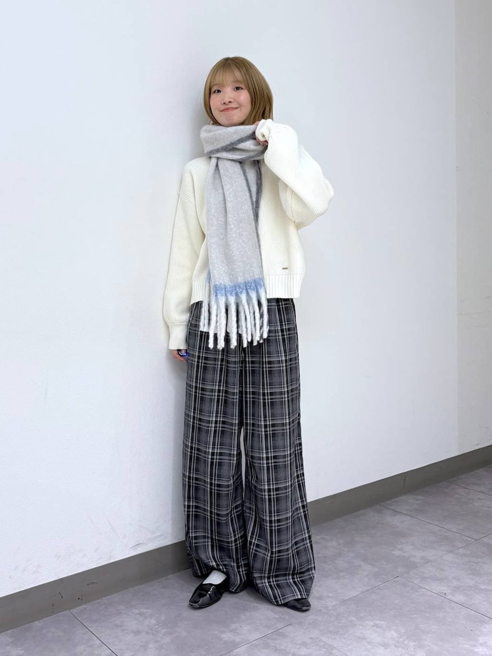 ホワイト系のニット/セーター、ブラック系のスラックス、ホワイト系のマフラーを着用したレディースの冬コーディネートの2枚目の写真