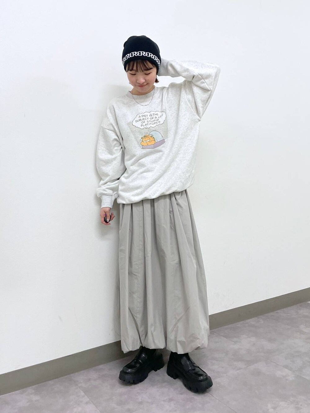 ブラック系のローファー、グレー系のスカート、ホワイト系のスウェットを着用したレディースの冬コーディネートの2枚目の写真