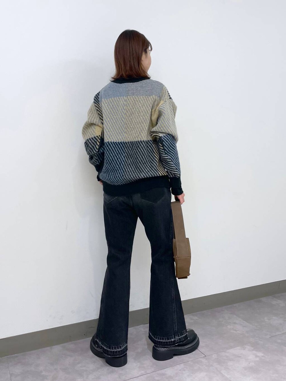 ブラック系のローファー、グレー系のニット/セーター、ブラック系のデニムパンツを着用したレディースの秋コーディネートの3枚目の写真