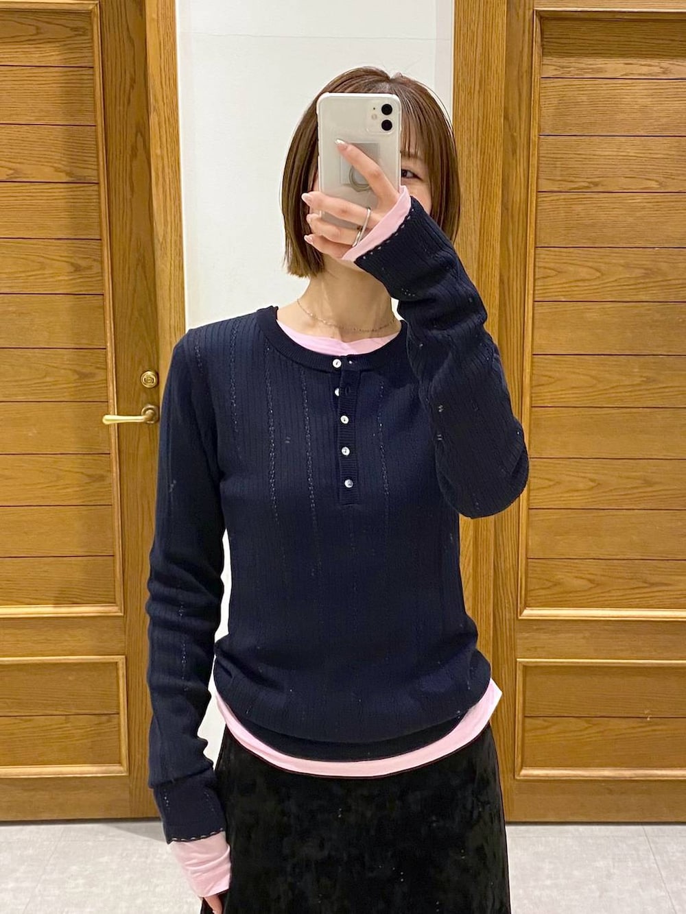 ブラック系のスカート、ブラック系のパンプス、ピンク系のTシャツ/カットソーを着用したレディースの冬コーディネートの6枚目の写真