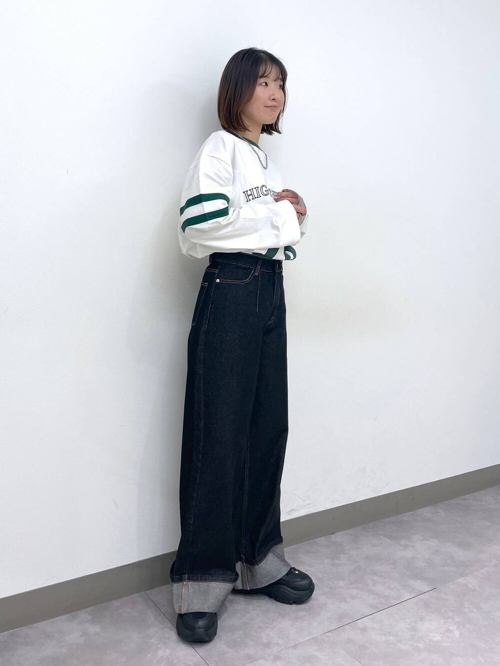 ホワイト系のTシャツ/カットソー、ブラック系のデニムパンツ、ブラック系のスニーカーを着用したレディースの春コーディネートの3枚目の写真