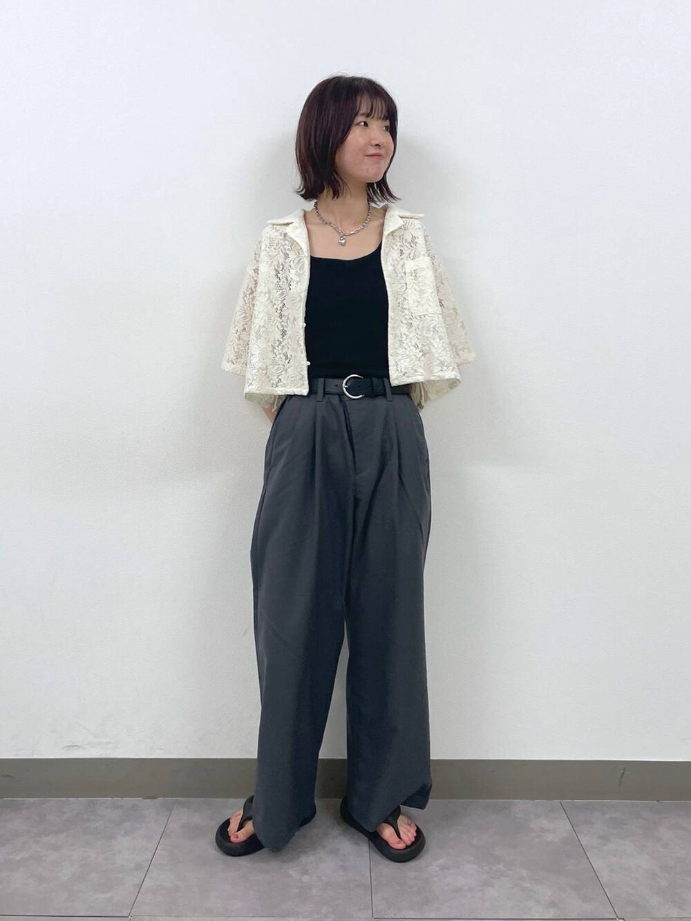 グレー系のスラックス、ホワイト系のシャツ/ブラウス、シルバー系のブレスレットを着用したレディースの夏コーディネートの2枚目の写真