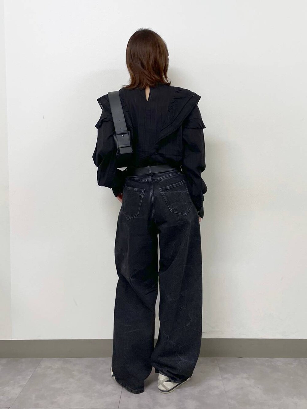 ブラック系のシャツ/ブラウス、ブラック系のショルダーバッグ、ブラック系のデニムパンツを着用したレディースの秋コーディネートの4枚目の写真