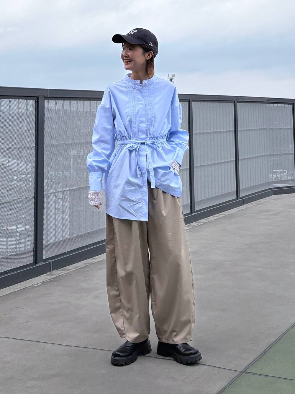 ベージュ系のスラックス、ブルー系のシャツ/ブラウスを着用したレディースの春コーディネートの5枚目の写真