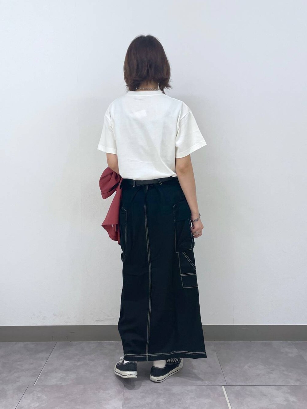 ブラック系のデニムスカート、ホワイト系のTシャツ/カットソー、レッド系のシャツ/ブラウスを着用したレディースの夏コーディネートの3枚目の写真