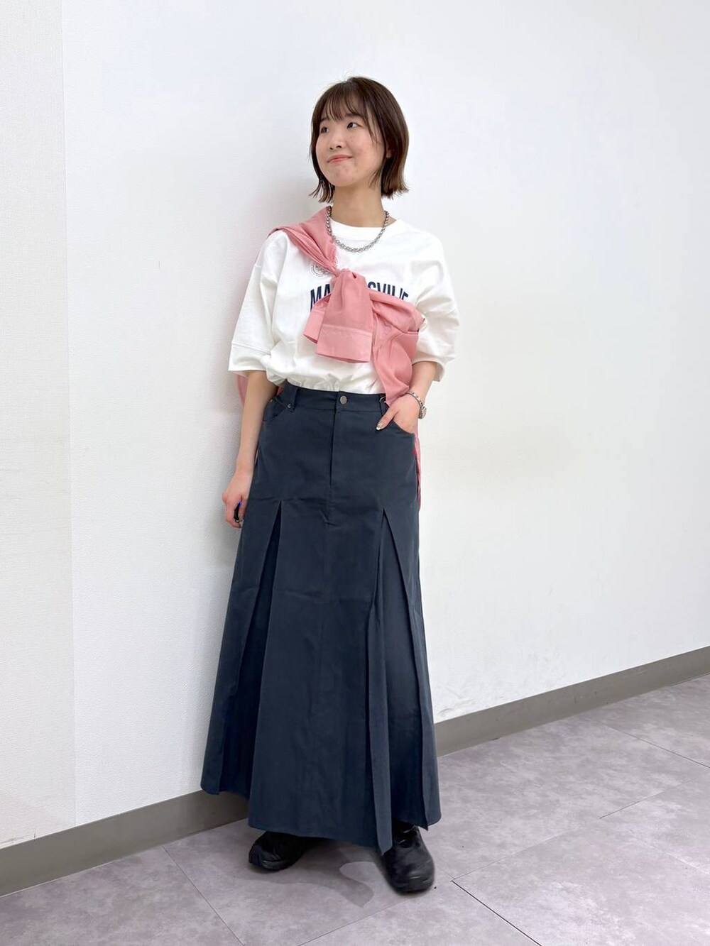 ホワイト系のTシャツ/カットソー、ブラック系のスニーカー、ブルー系のスカートを着用したレディースの春コーディネートの5枚目の写真