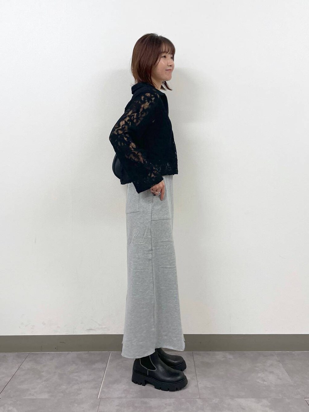 ブラック系のショルダーバッグ、ブラック系のシャツ/ブラウス、ブラック系のブーツを着用したレディースの秋コーディネートの4枚目の写真