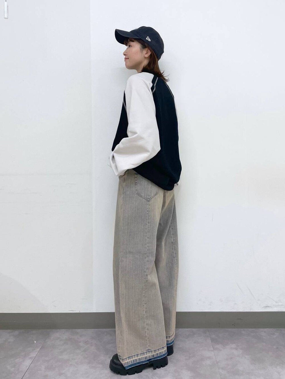 ブラック系のブーツ、ブラック系のスウェット、ブルー系のデニムパンツを着用したレディースの冬コーディネートの4枚目の写真