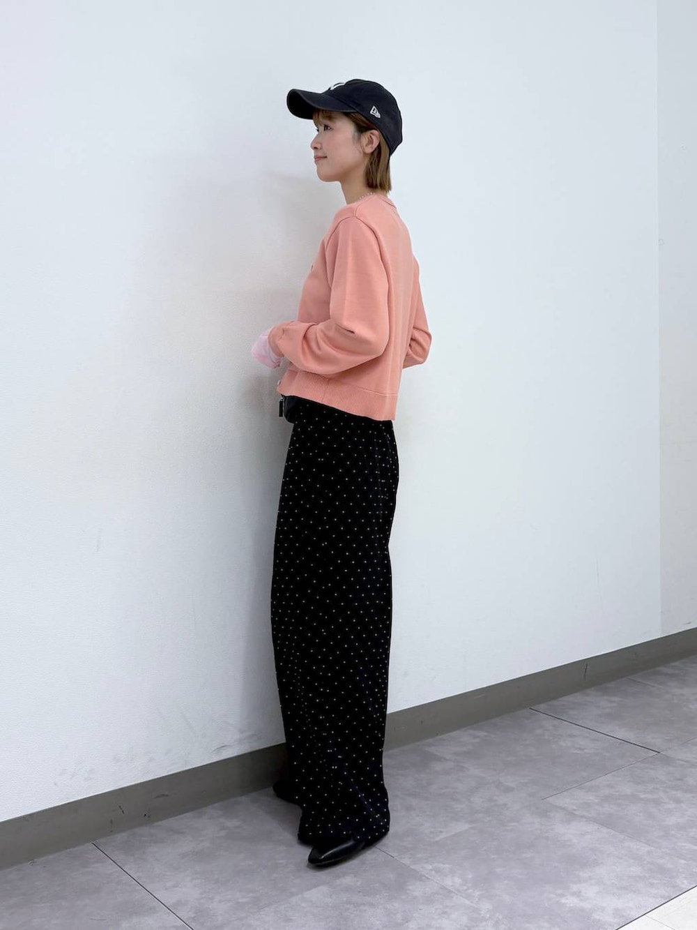 ブラック系のパンプス、ブラック系のボディバッグ/ウエストポーチ、ブラック系のスラックスを着用したレディースの春コーディネートの3枚目の写真