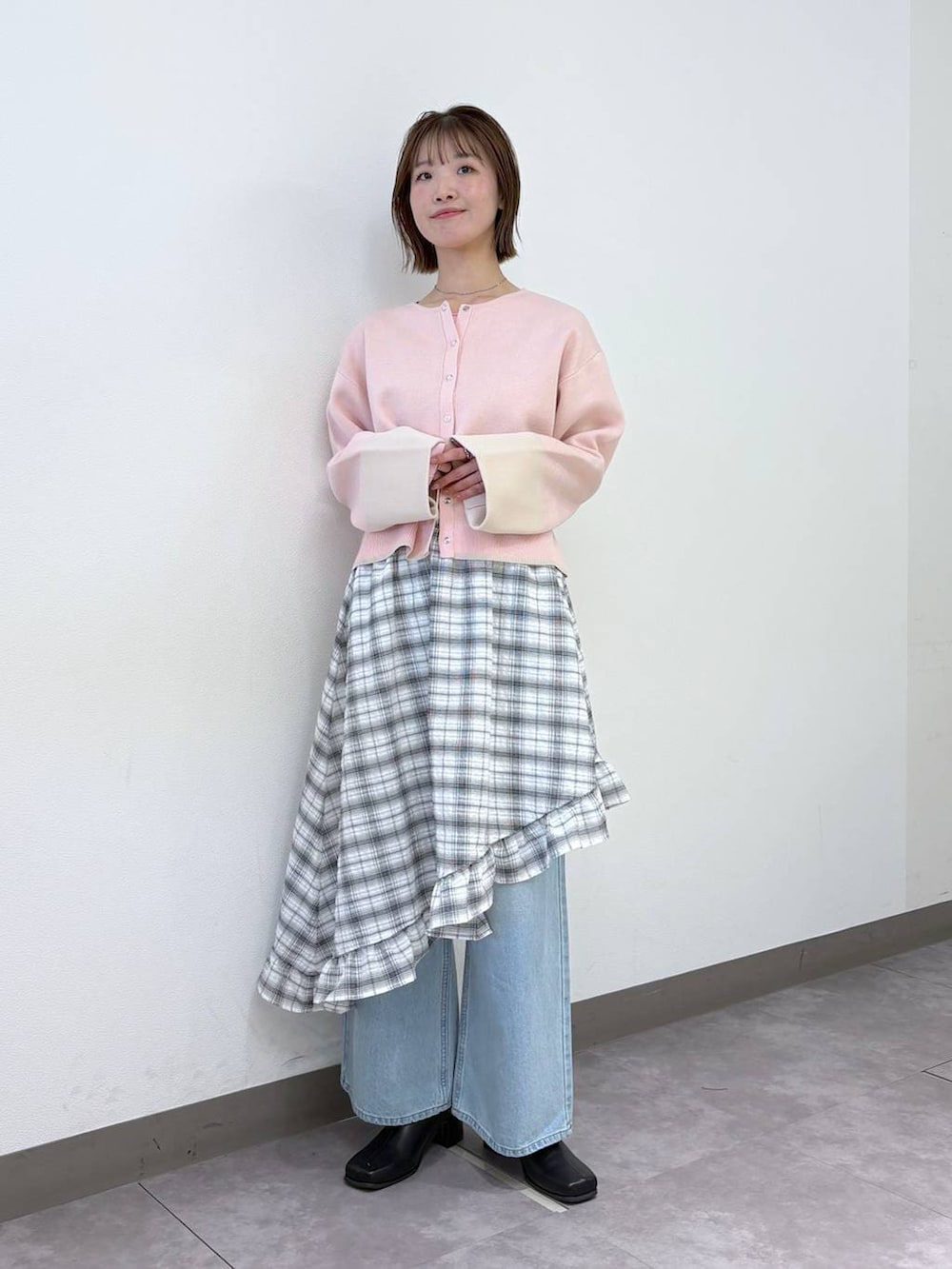 ブルー系のデニムパンツ、ピンク系のカーディガン/ボレロ、ブラック系のブーツを着用したレディースの冬コーディネートの5枚目の写真