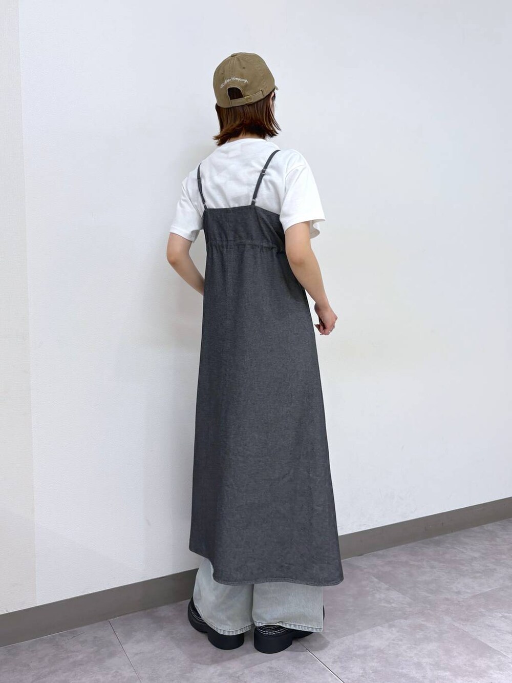 ブラック系のローファー、ブルー系のデニムパンツ、グレー系のワンピースを着用したレディースの春コーディネートの5枚目の写真