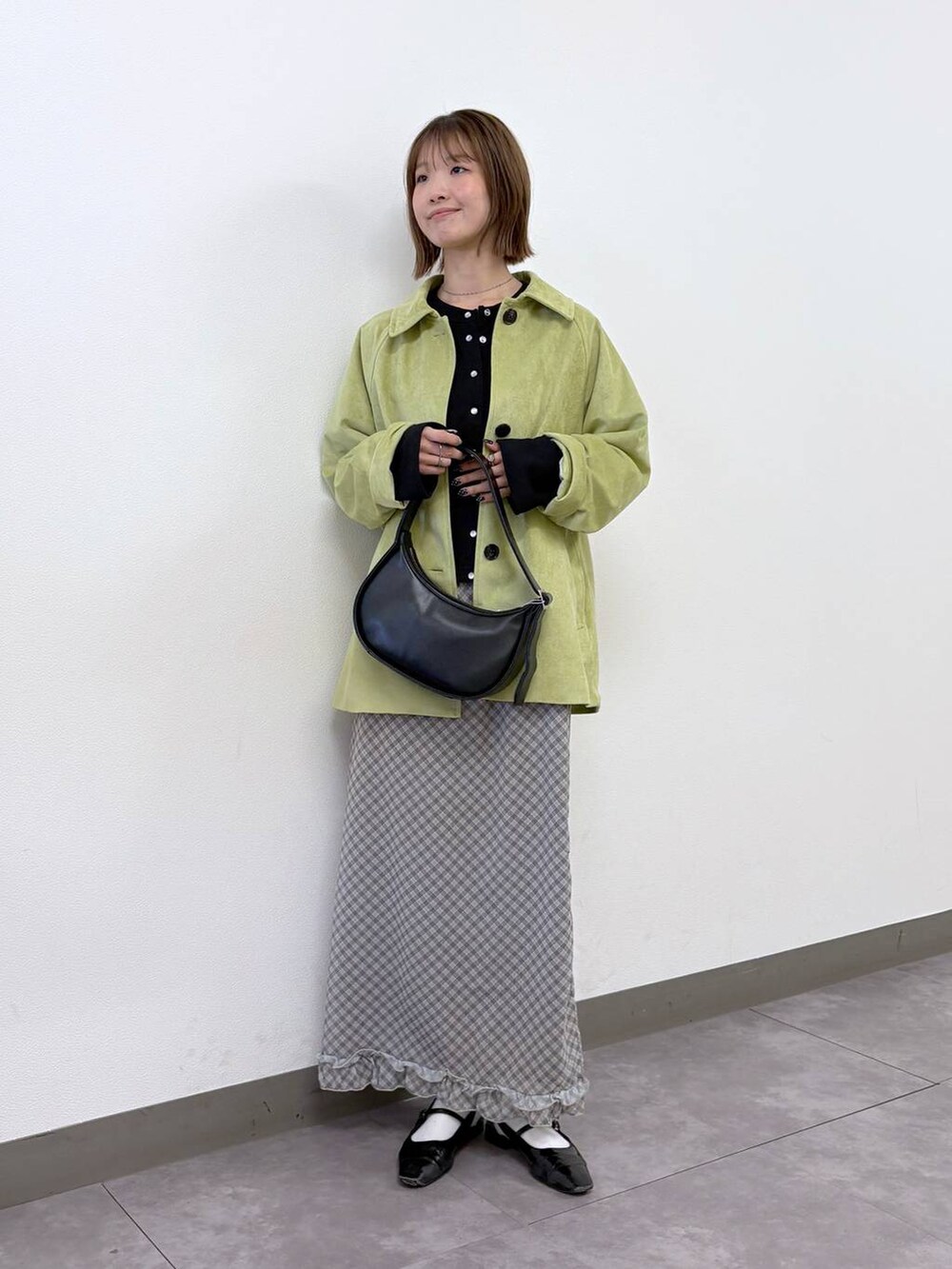 ブラック系のカーディガン/ボレロ、ブラック系のショルダーバッグ、グリーン系のブルゾンを着用したレディースの春コーディネートの2枚目の写真