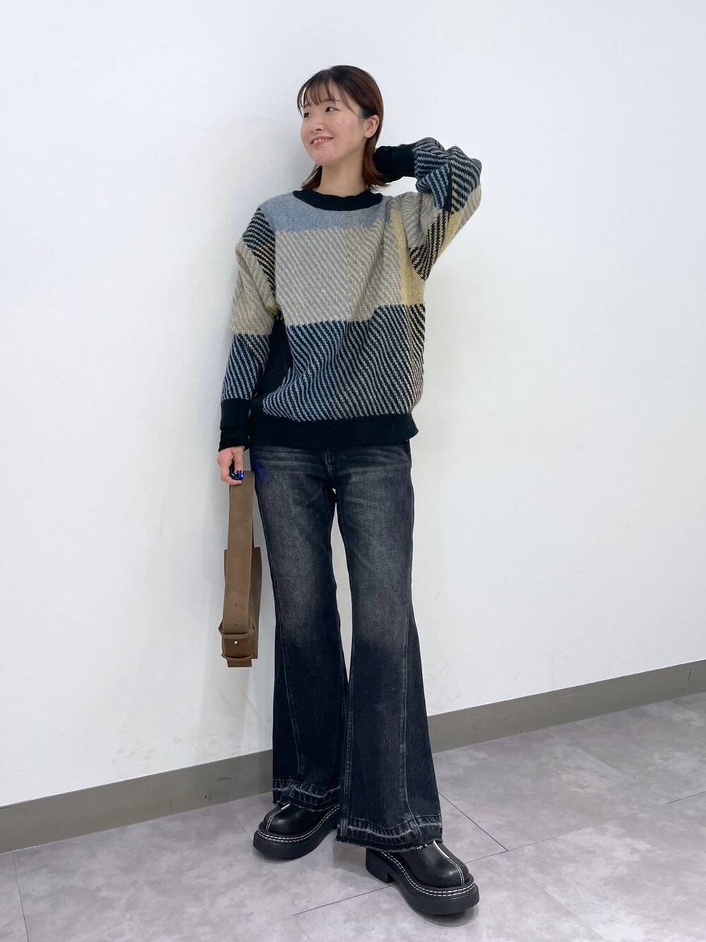 ブラック系のローファー、グレー系のニット/セーター、ブラック系のデニムパンツを着用したレディースの秋コーディネートの4枚目の写真