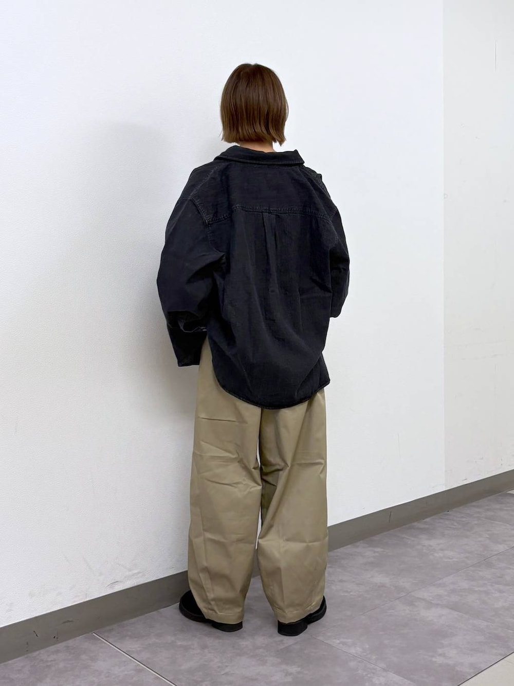 ベージュ系のチノパンツ、ブラック系のボディバッグ/ウエストポーチ、ブルー系のベストを着用したレディースの春コーディネートの5枚目の写真