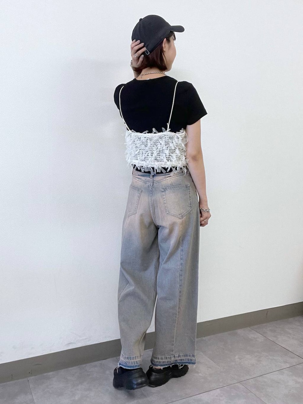 ホワイト系のキャミソール、ブルー系のデニムパンツ、ブラック系のサンダルを着用したレディースの夏コーディネートの3枚目の写真