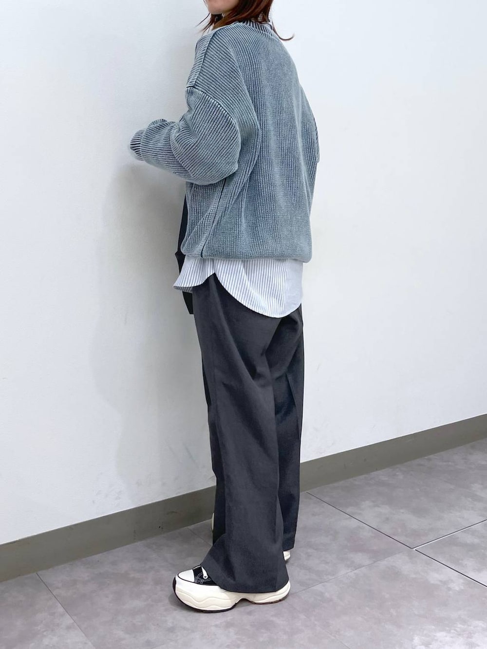 グレー系のスラックス、ブラック系のスニーカー、ブラック系のショルダーバッグを着用したレディースの冬コーディネートの4枚目の写真