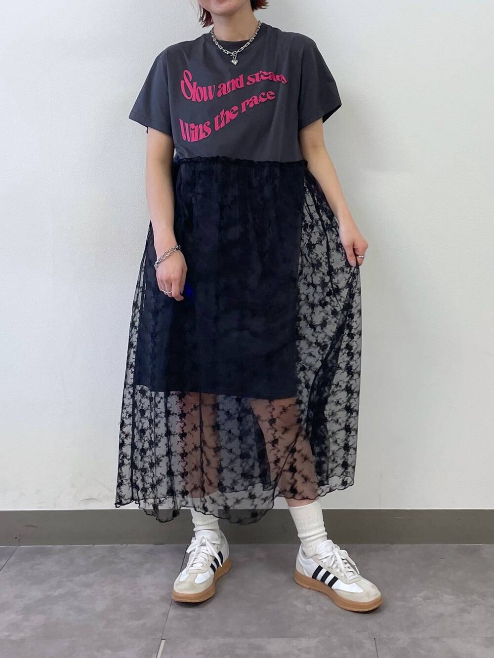 グレー系のワンピース、ブルー系のキャップ、シルバー系のブレスレットを着用したレディースの夏コーディネートの2枚目の写真