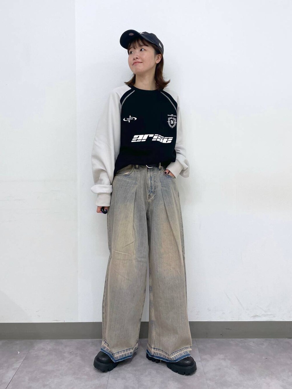 ブラック系のブーツ、ブラック系のスウェット、ブルー系のデニムパンツを着用したレディースの冬コーディネートの3枚目の写真