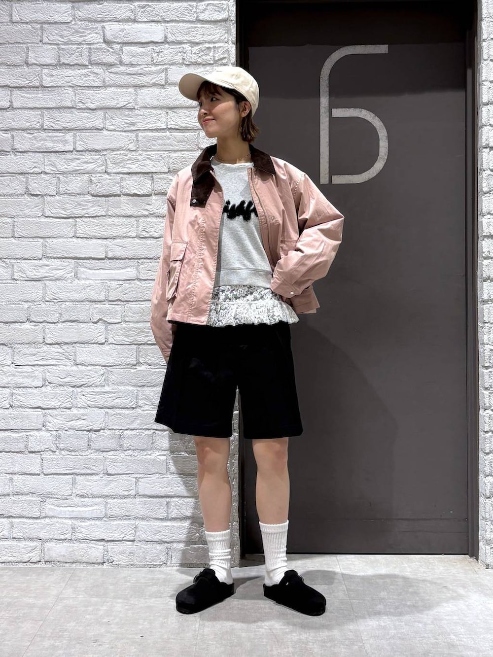 ブラック系のスラックス、ピンク系のブルゾン、グレー系のスウェットを着用したレディースの冬コーディネートの3枚目の写真