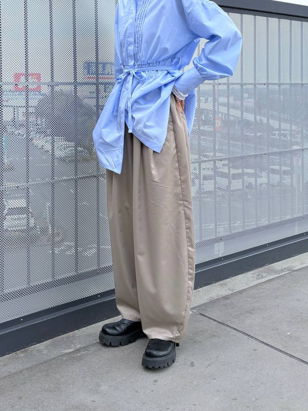 ベージュ系のスラックス、ブルー系のシャツ/ブラウスを着用したレディースの春コーディネートの4枚目の写真