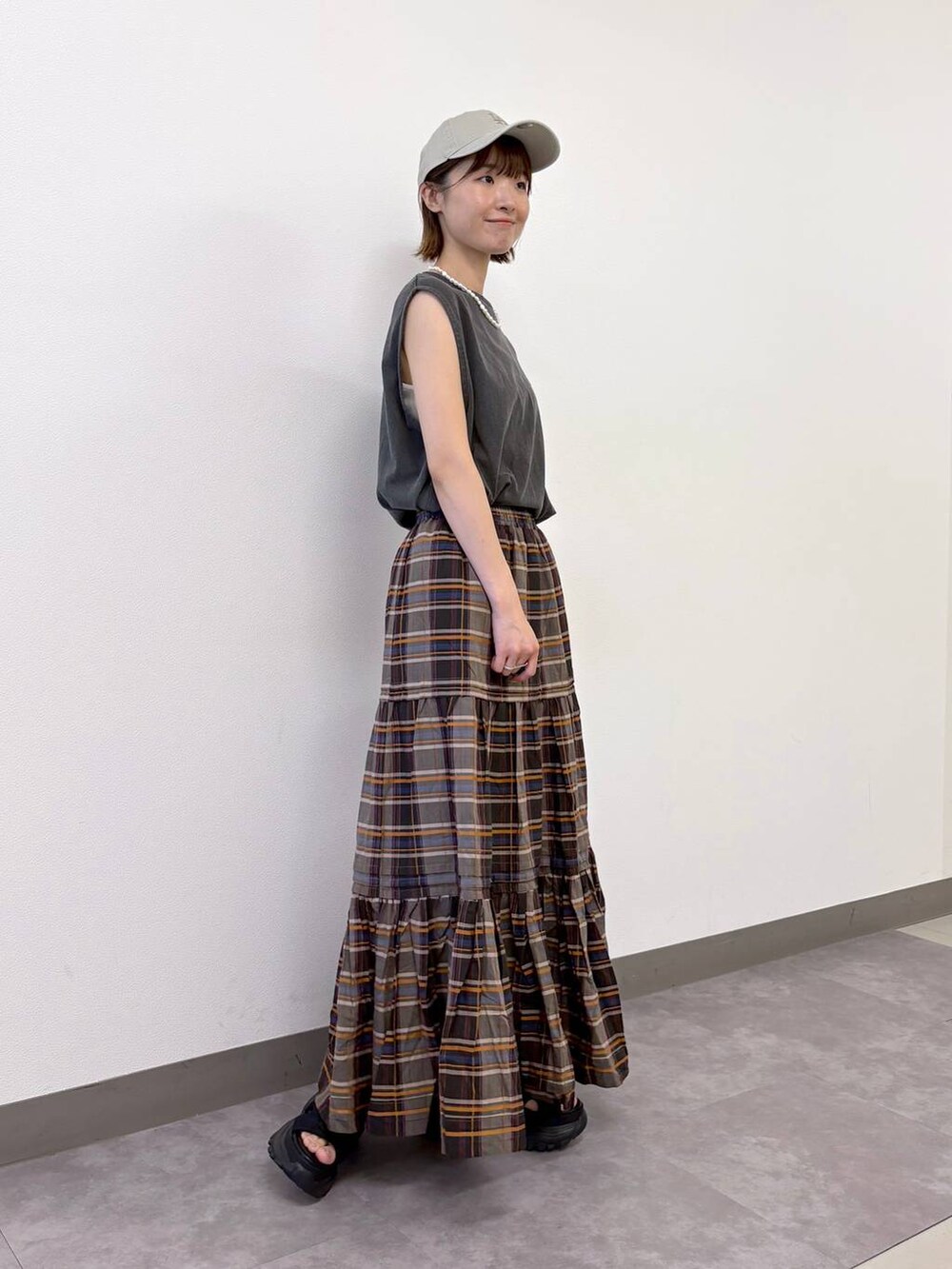 ブラック系のサンダル、ブラウン系のスカート、ブラック系のTシャツ/カットソーを着用したレディースの夏コーディネートの5枚目の写真