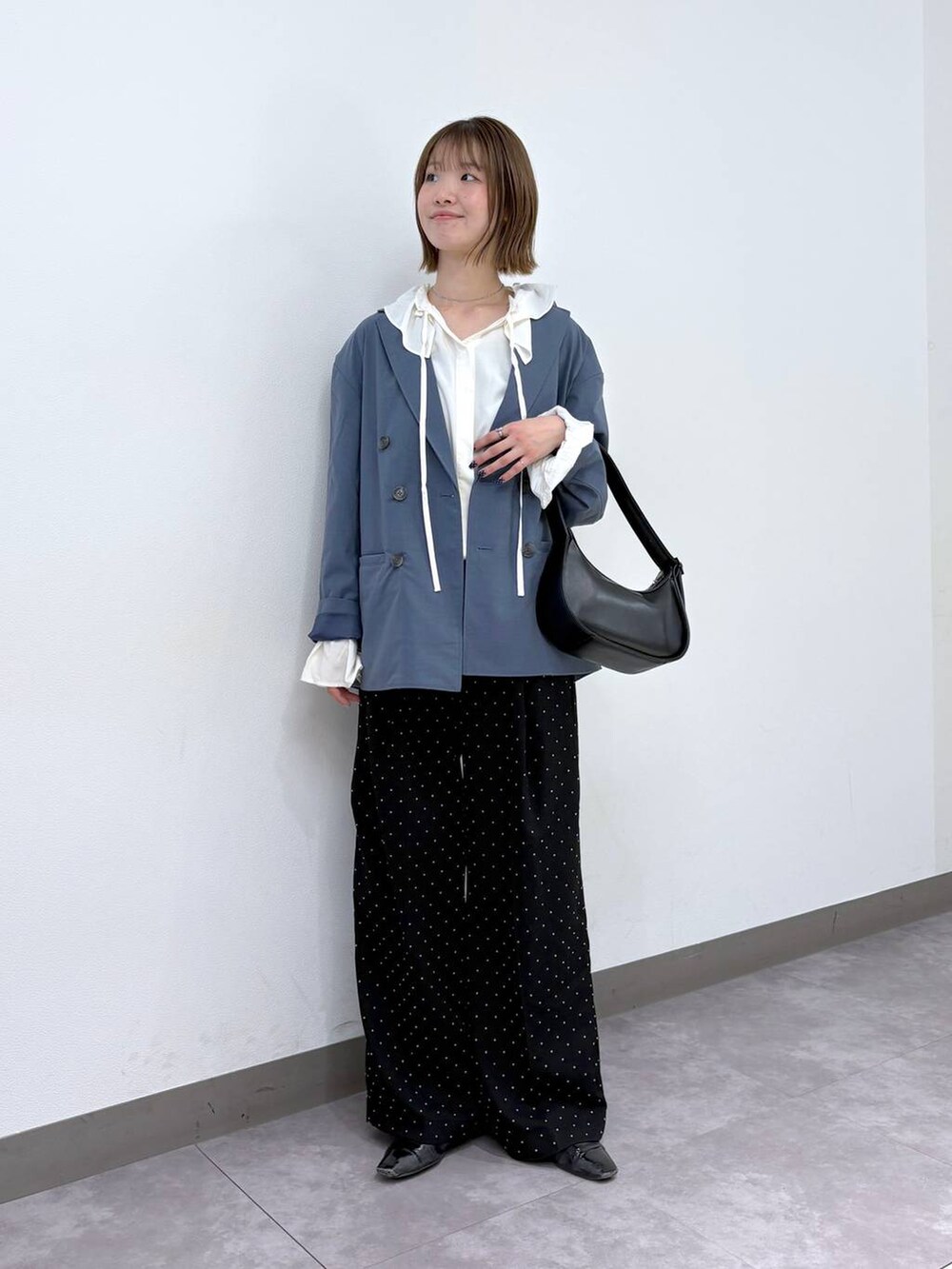 ブルー系のテーラードジャケット、ブラック系のスラックス、ホワイト系のシャツ/ブラウスを着用したレディースの冬コーディネートの2枚目の写真