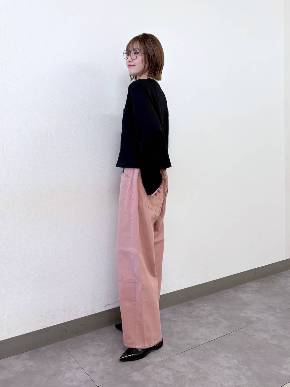 ブラック系のパンプス、ブラック系のカーディガン/ボレロ、ピンク系のデニムパンツを着用したレディースの冬コーディネートの3枚目の写真