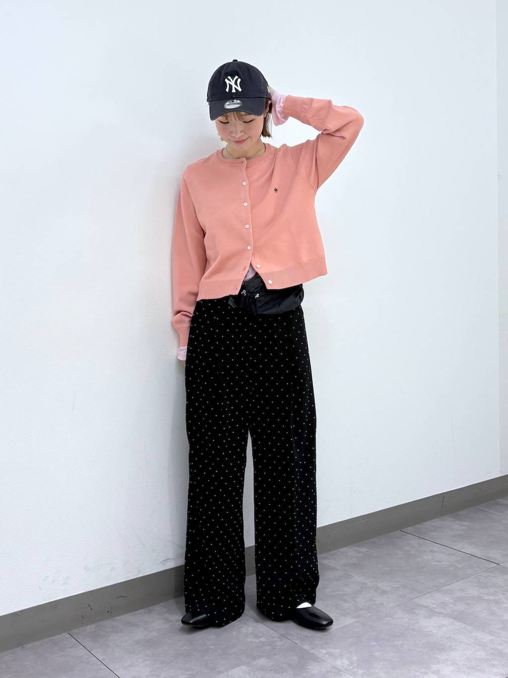 ブラック系のパンプス、ブラック系のボディバッグ/ウエストポーチ、ブラック系のスラックスを着用したレディースの春コーディネートの2枚目の写真