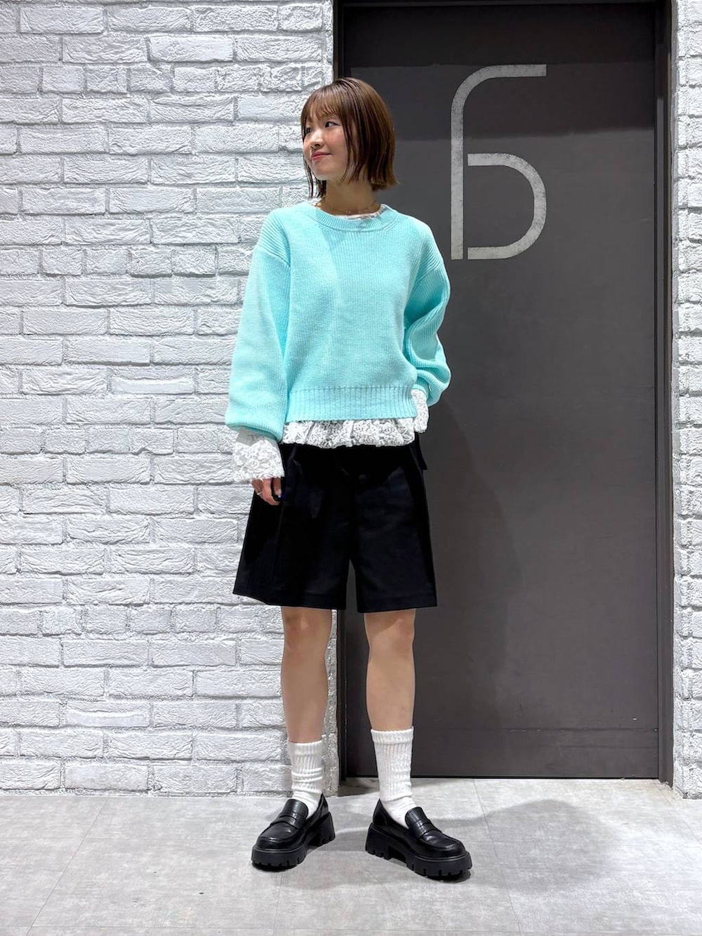 ブラック系のローファー、ブラック系のスラックス、ブルー系のニット/セーターを着用したレディースの冬コーディネートの2枚目の写真