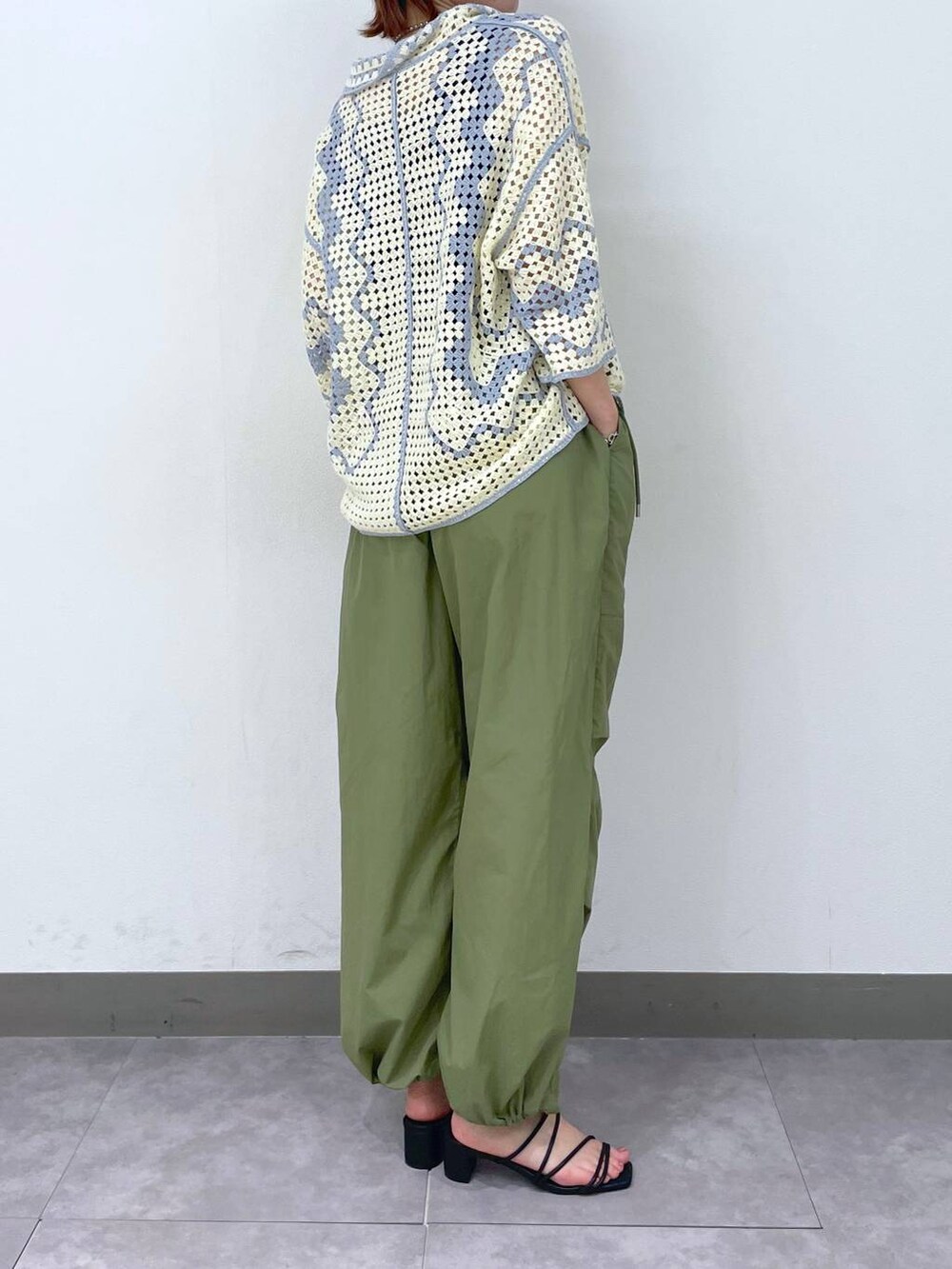 ブラック系のサンダル、ホワイト系のカーディガン/ボレロ、グリーン系のカーゴパンツを着用したレディースの夏コーディネートの2枚目の写真