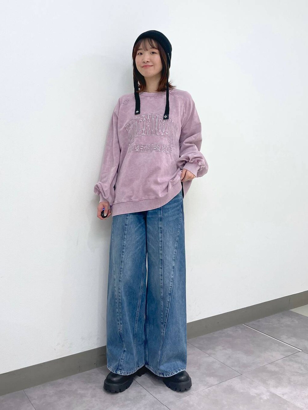 ブラック系のブーツ、ピンク系のスウェット、ブルー系のデニムパンツを着用したレディースの冬コーディネートの2枚目の写真