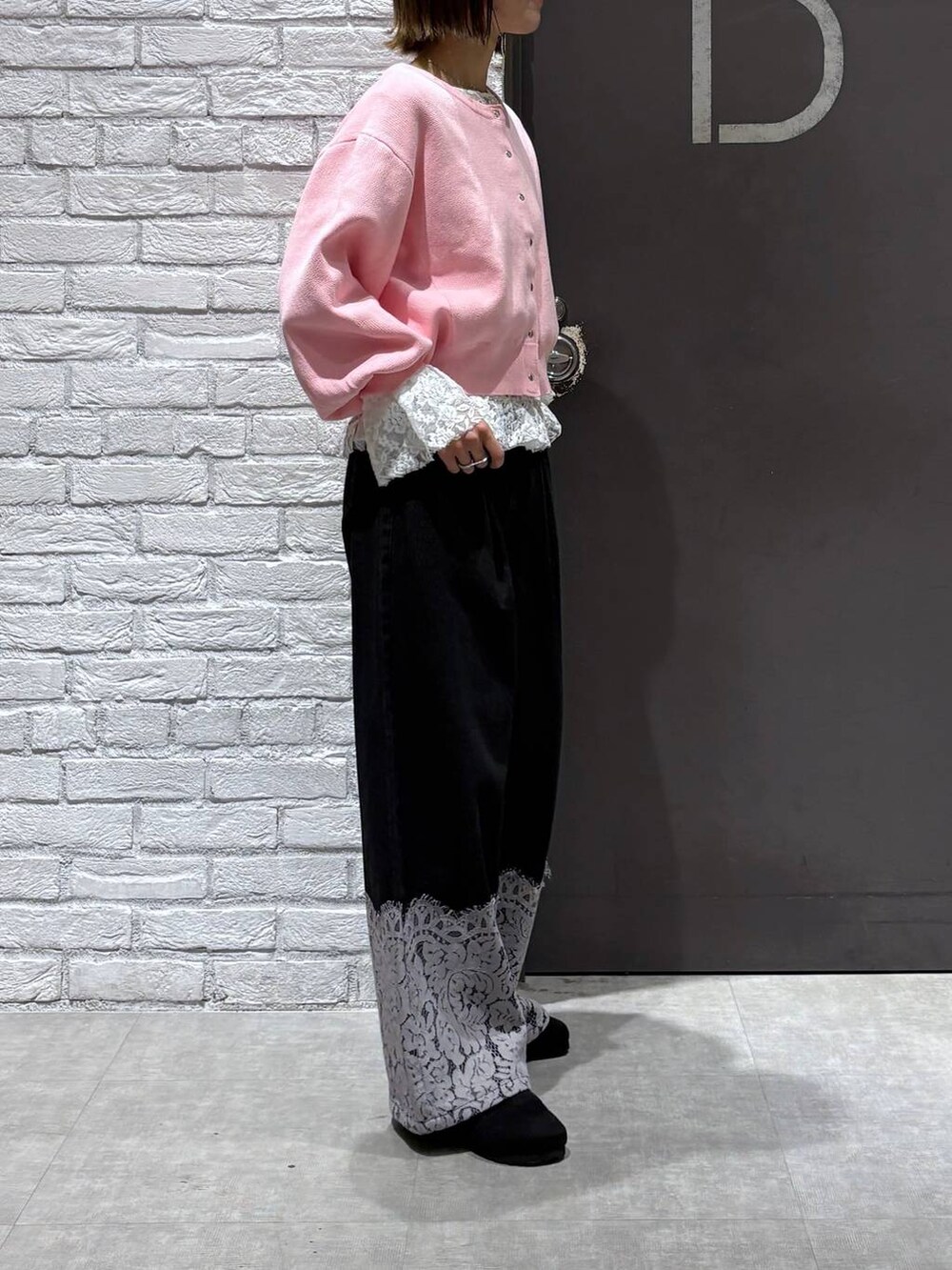 ピンク系のカーディガン/ボレロ、ブラック系のデニムパンツ、ブラック系のモカシン/デッキシューズを着用したレディースの冬コーディネートの4枚目の写真