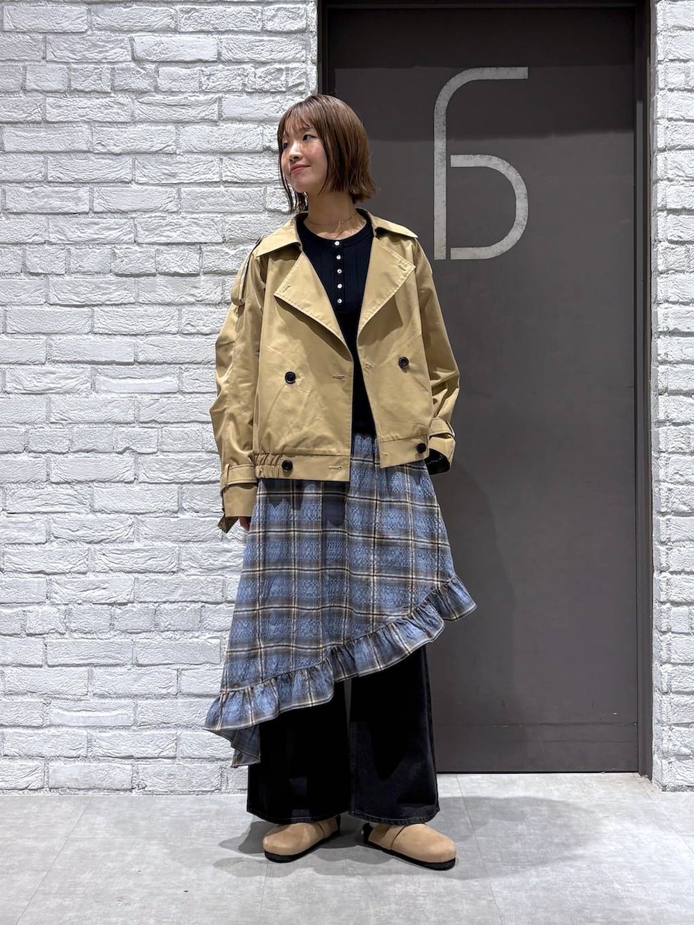 ブラック系のデニムパンツ、ベージュ系のトレンチコート、ブルー系のニット/セーターを着用したレディースの冬コーディネートの6枚目の写真