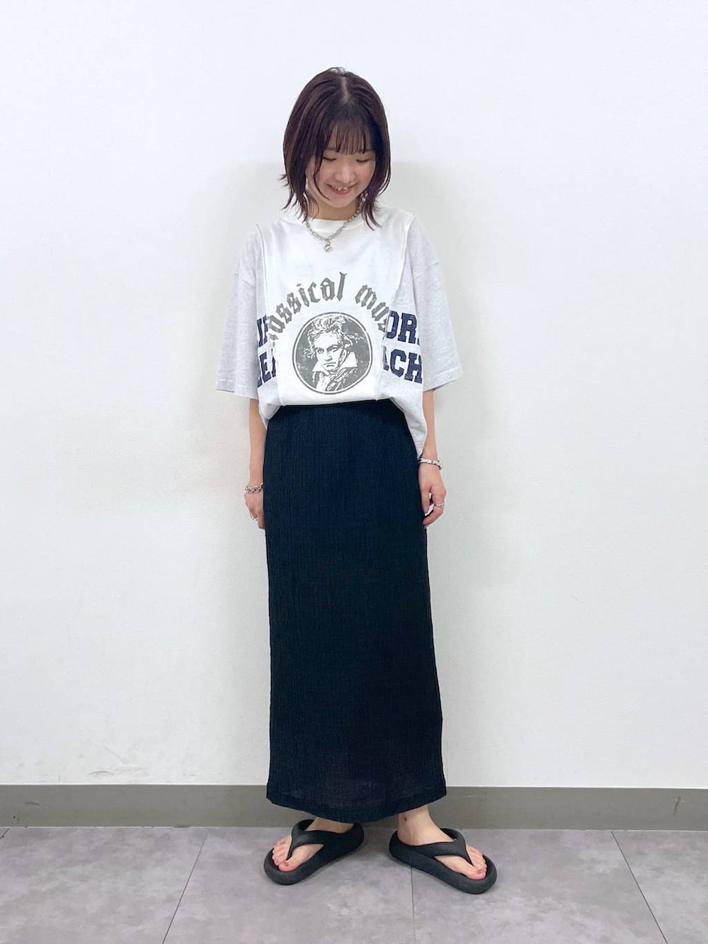 ブラック系のスカート、ホワイト系のTシャツ/カットソー、その他のネックレスを着用したレディースの夏コーディネートの5枚目の写真