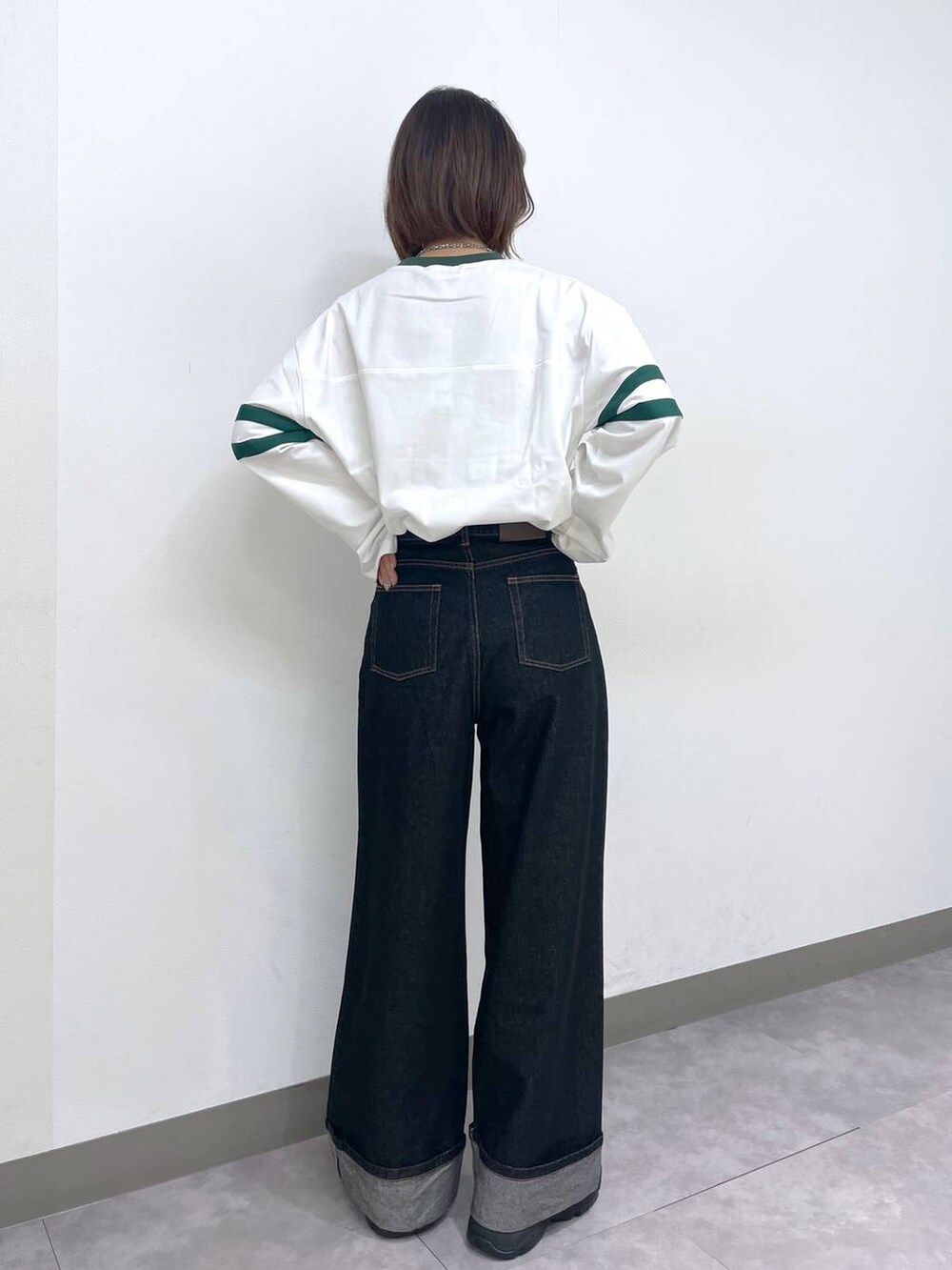 ホワイト系のTシャツ/カットソー、ブラック系のデニムパンツ、ブラック系のスニーカーを着用したレディースの春コーディネートの4枚目の写真