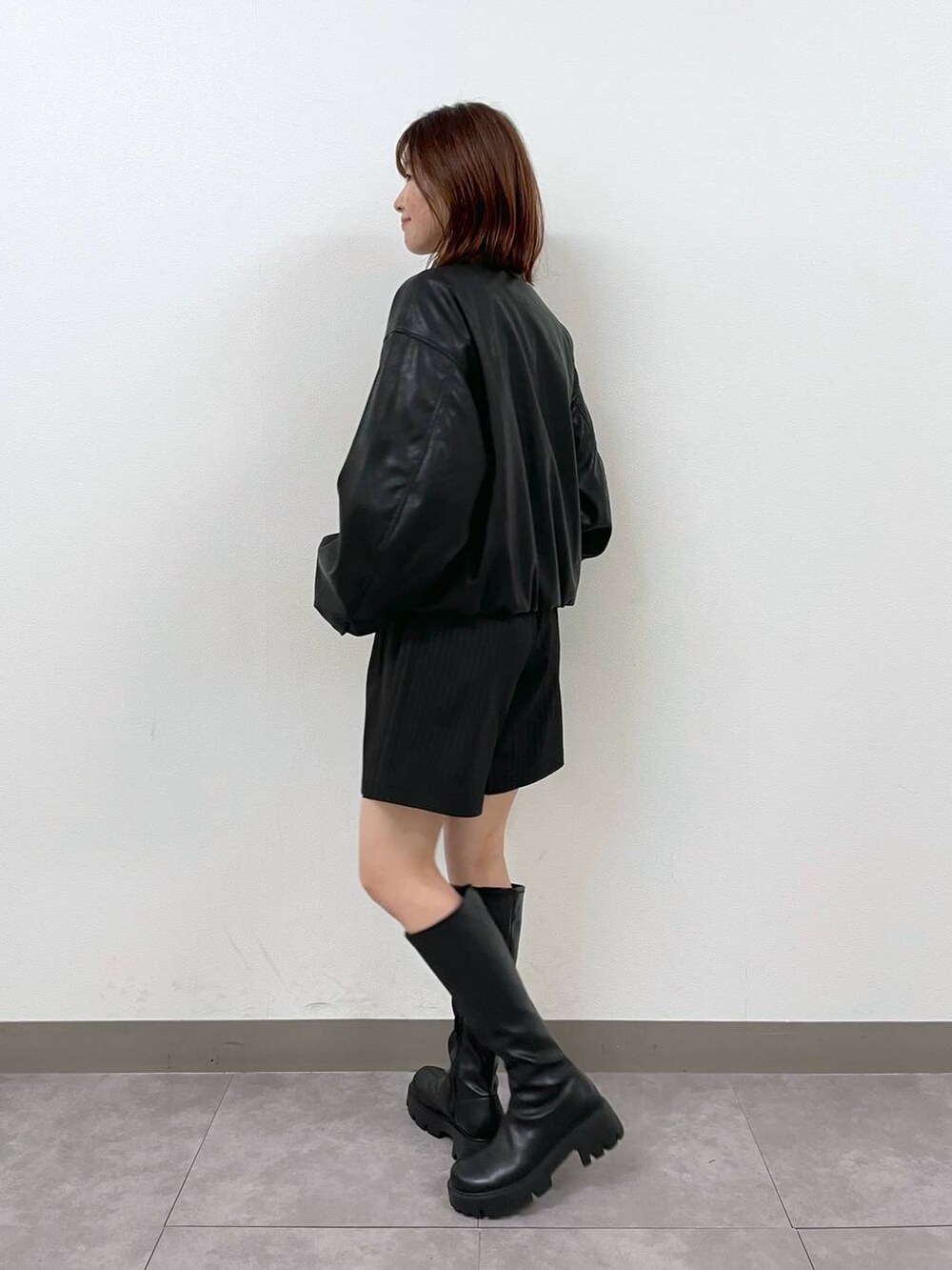 ブラック系のブルゾン、ブラック系のブーツ、ブラック系のスカートを着用したレディースの秋コーディネートの3枚目の写真