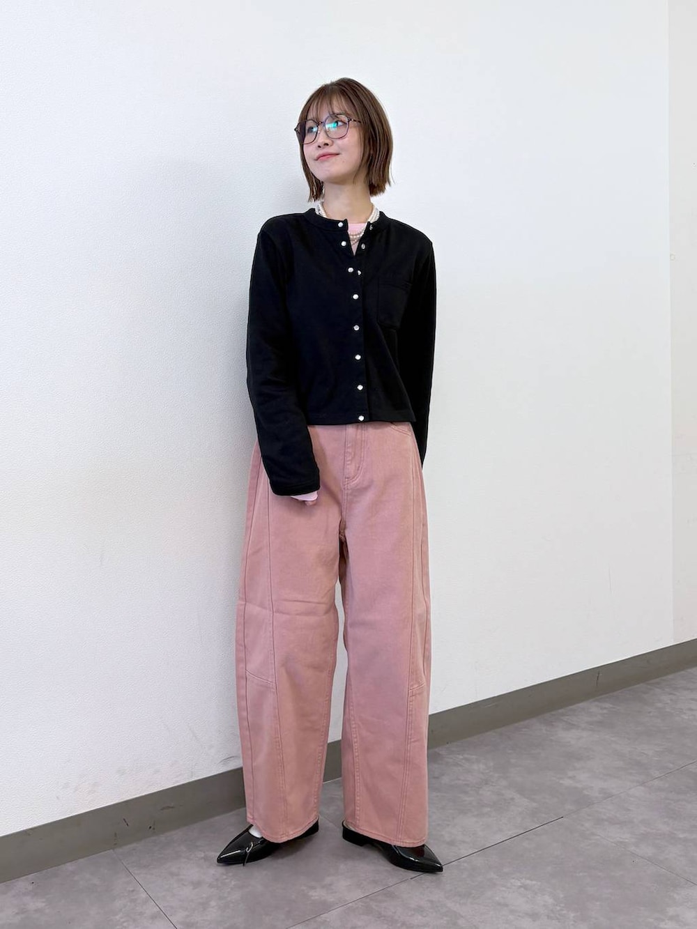 ブラック系のパンプス、ブラック系のカーディガン/ボレロ、ピンク系のデニムパンツを着用したレディースの冬コーディネートの5枚目の写真