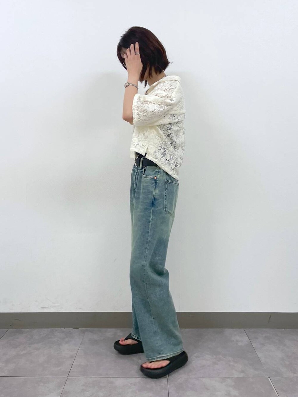 ブルー系のデニムパンツ、ホワイト系のシャツ/ブラウス、シルバー系のブレスレットを着用したレディースの夏コーディネートの2枚目の写真