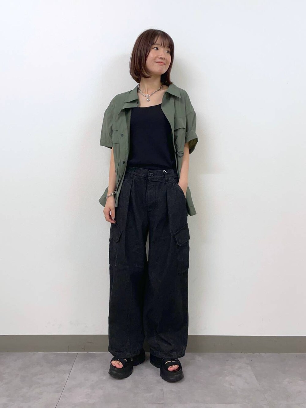 グレー系のデニムパンツ、グリーン系のシャツ/ブラウス、ブラック系のサンダルを着用したレディースの夏コーディネートの5枚目の写真