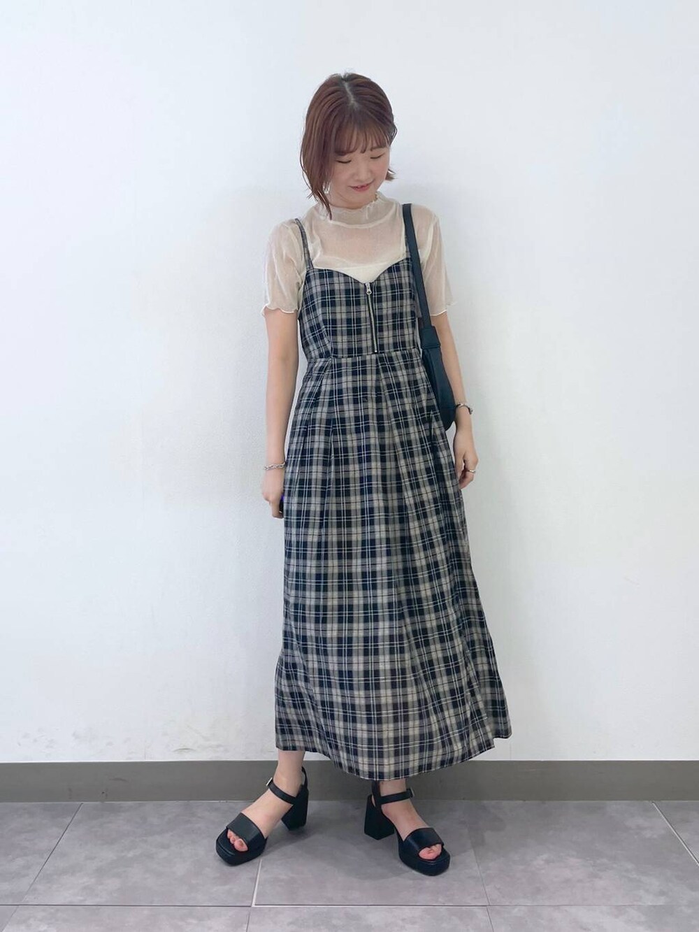 ブラック系のサンダル、ブラック系のワンピース、ホワイト系のキャミソールを着用したレディースの夏コーディネートの4枚目の写真