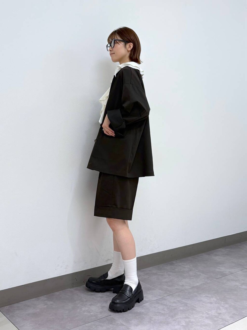 ブラック系のローファー、ホワイト系のシャツ/ブラウス、ブラウン系のスラックスを着用したレディースの夏コーディネートの3枚目の写真