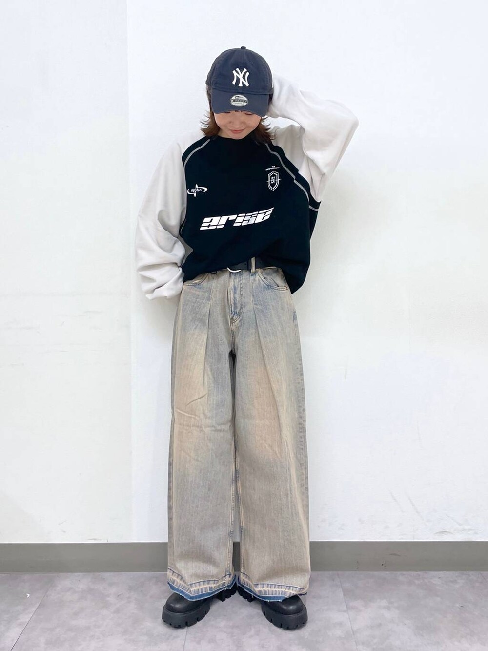 ブラック系のブーツ、ブラック系のスウェット、ブルー系のデニムパンツを着用したレディースの冬コーディネートの2枚目の写真