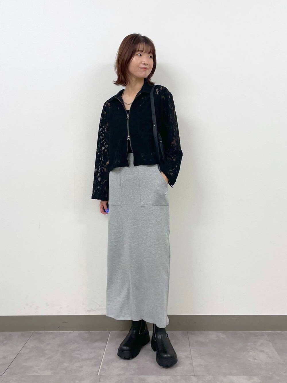 ブラック系のショルダーバッグ、ブラック系のシャツ/ブラウス、ブラック系のブーツを着用したレディースの秋コーディネートの7枚目の写真