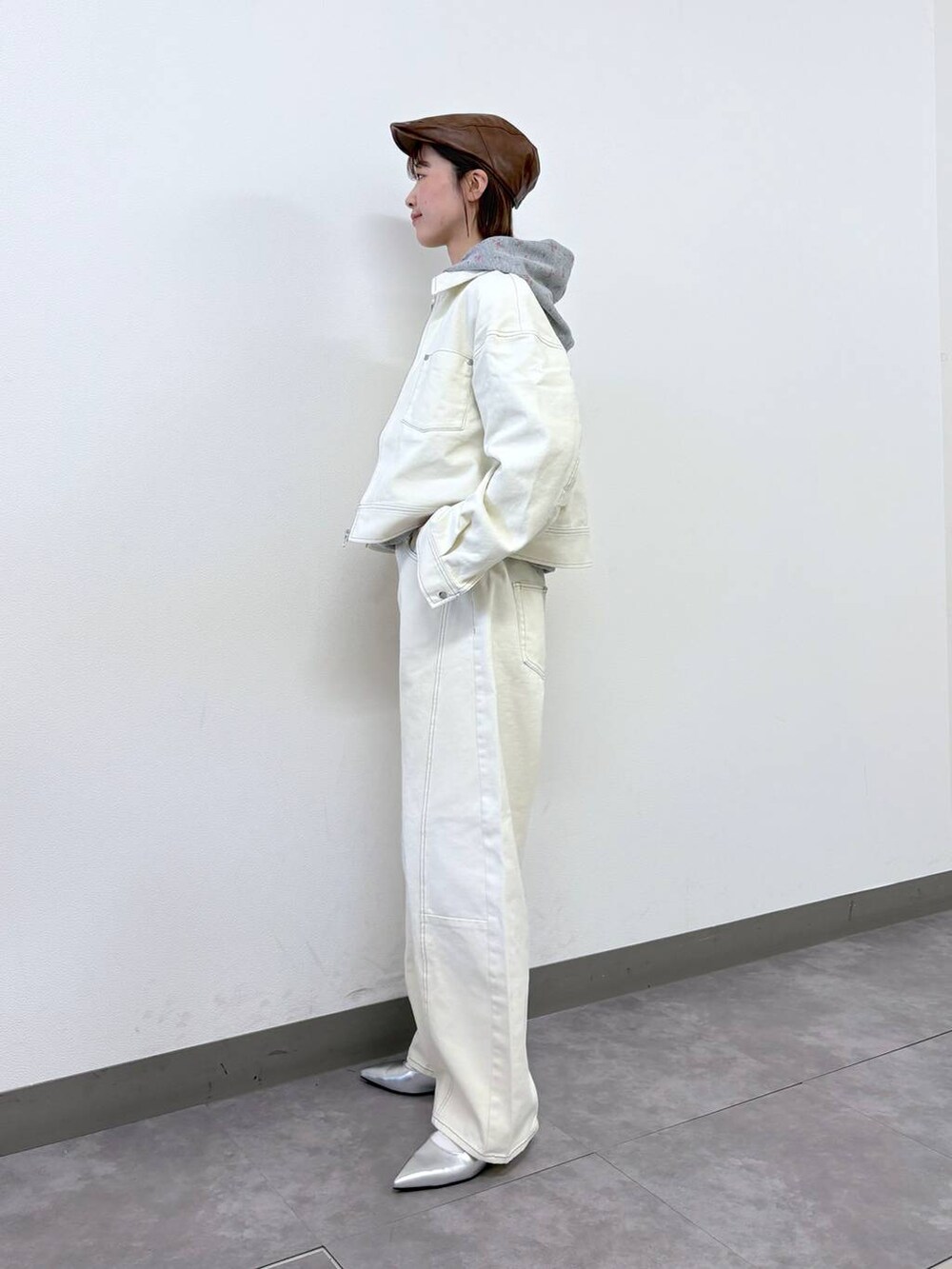 シルバー系のパンプス、ホワイト系のデニムジャケット、ホワイト系のデニムパンツを着用したレディースの冬コーディネートの2枚目の写真